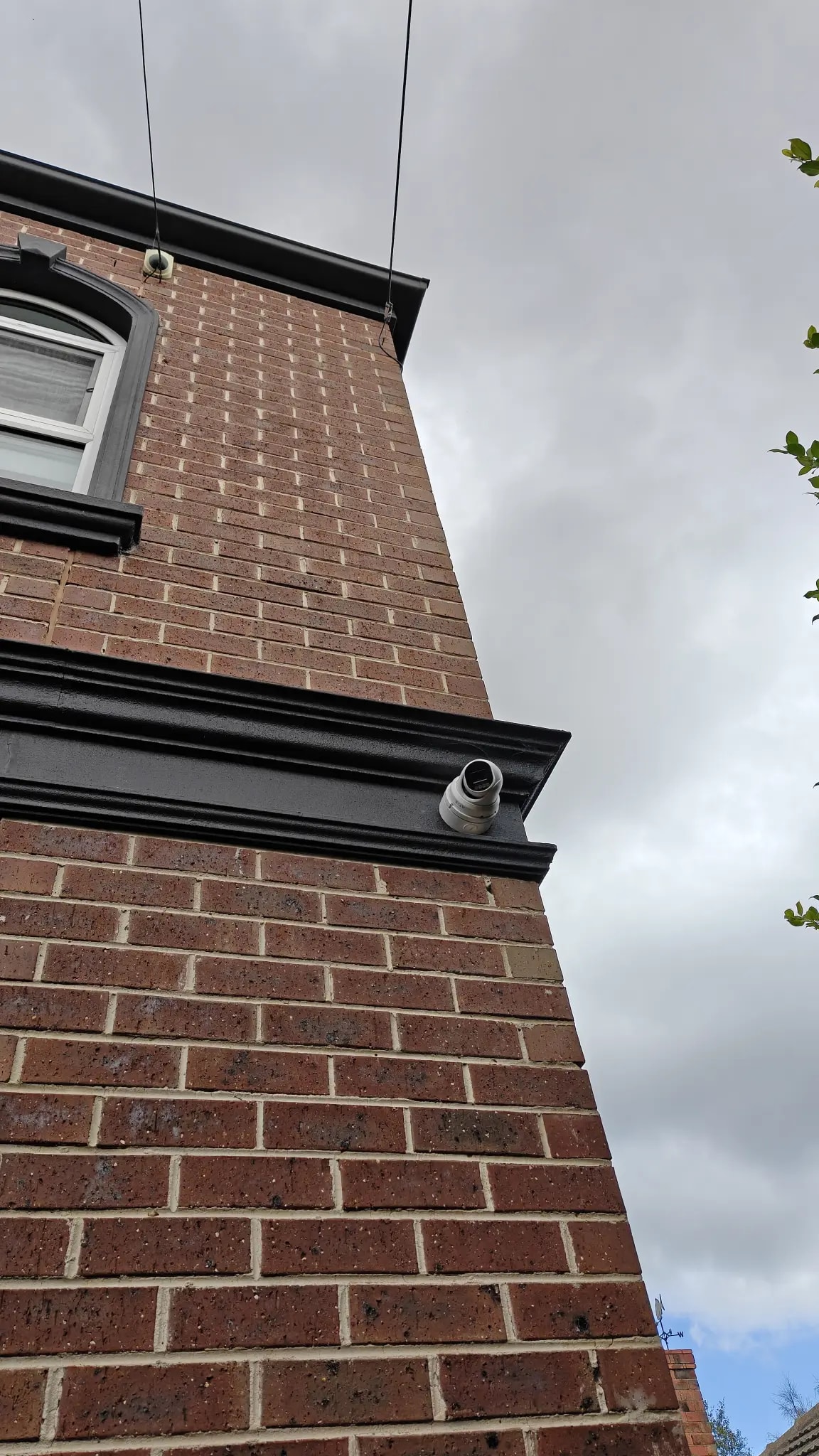 Exterior CCTV camera installed on brick home
